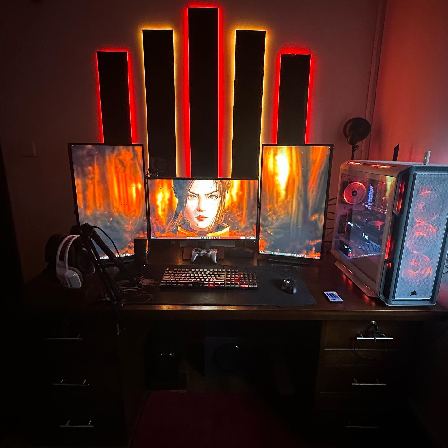 Gaming setup with headphones and PC tower illuminated by blue lighting